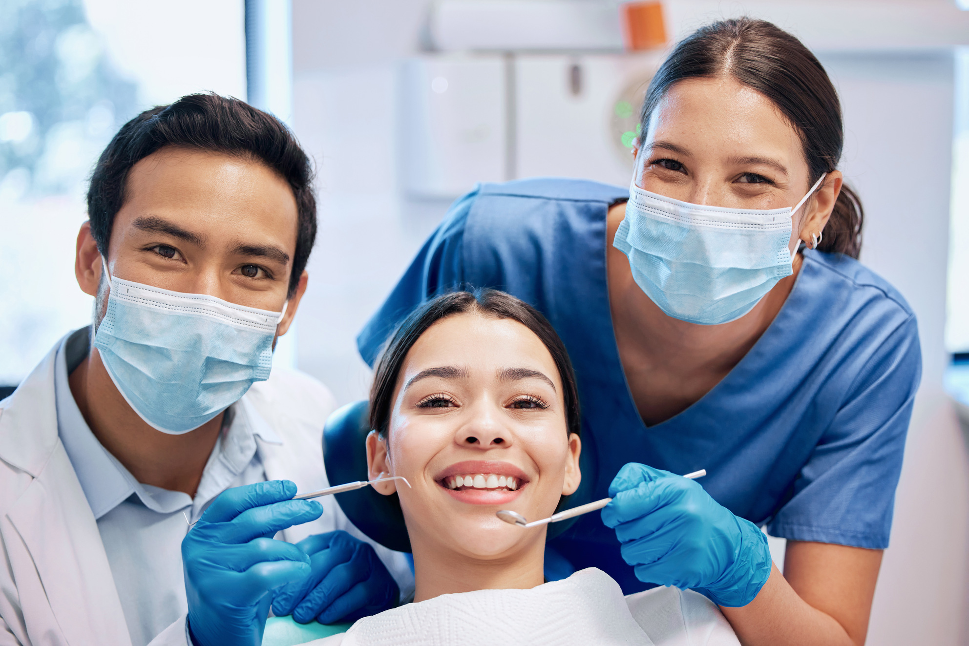 Equipo de dentistas atendiendo a diferentes pacientes en una clínica dental moderna de Madrid, ambiente profesional y acogedor
